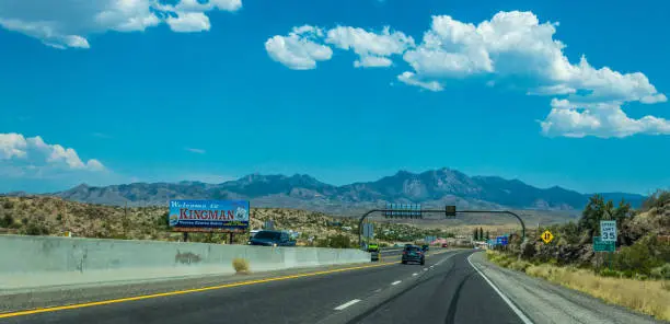 Kingman, Arizona, USA - June 15, 2017: Freeway and cars on the way to Kingman city in Arizona, USA. Blue sky and collapsing rocks along the highway. Southwest US travel by car