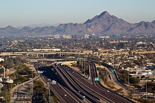 Here's a short alt tag for the image: `Phoenix freeway interchange and mountains`