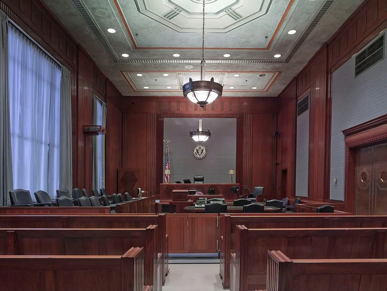 Empty courtroom with wooden benches.