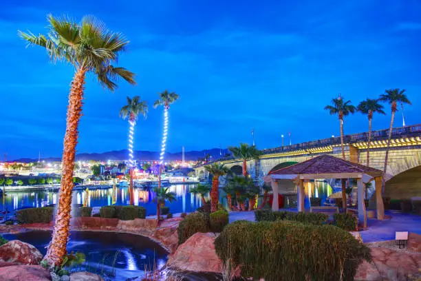 Lake Havasu City, Arizona, USA - April 1, 2019: Evening view of the London Bridge and downtown district along the shoreline trail