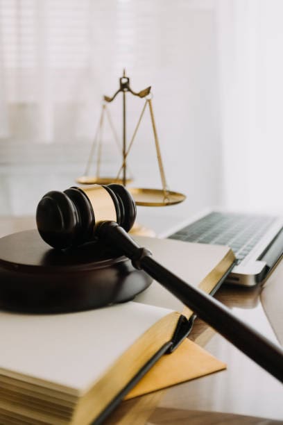 law books and scales of justice on desk in library of law firm. jurisprudence legal education concept.